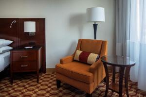 a room with a chair and a table and a bed at Indianapolis Marriott East in Indianapolis