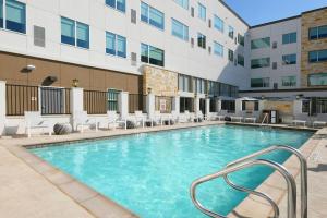 uma piscina com cadeiras e um edifício em Element Austin Round Rock em Round Rock