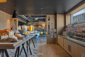 a kitchen with a long table with food on it at Aloft Aberdeen TECA in Aberdeen