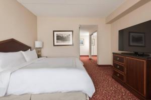 a hotel room with a bed and a flat screen tv at Chicago Marriott Northwest in Hoffman Estates