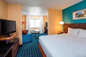 a hotel room with a bed and a flat screen tv at Fairfield Inn & Suites Cheyenne in Cheyenne