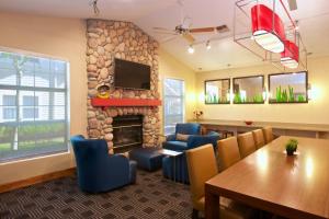a living room with a fireplace and a table and chairs at TownePlace Suites by Marriott Seattle Southcenter in Kent