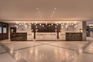 a lobby with a reception desk and lights at Sheraton Frankfurt Airport Hotel & Conference Center in Frankfurt