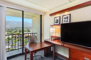 a room with a desk and a large screen television at Courtyard by Marriott Los Angeles Pasadena/Monrovia in Monrovia