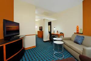 a living room with a couch and a flat screen tv at Fairfield Inn & Suites Fresno Clovis in Clovis