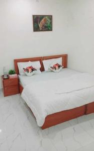 OYO Hotel Green Star في Sohna: غرفة نوم بسرير ذو شراشف ووسائد بيضاء