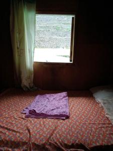 a purple towel sitting on the floor in front of a window at Batad Family Inn and Hidden Hut in Banaue