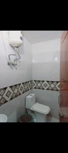 OYO Hotel Green Star في Sohna: حمام مع مرحاض واضاءة ومغسلة