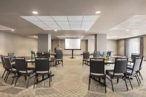 una sala conferenze con tavoli, sedie e schermo di Hotel Northland, Autograph Collection a Green Bay