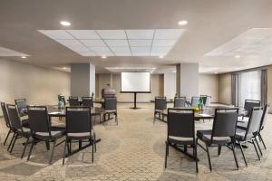 a conference room with tables and chairs and a screen at Hotel Northland, Autograph Collection in Green Bay
