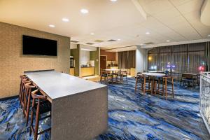 a lobby with a bar and tables and chairs at Fairfield Inn & Suites Tulsa Downtown Arts District in Tulsa
