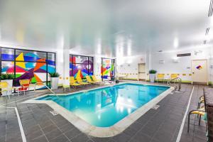 a pool in a hotel room with colorful art on the walls at Fairfield Inn & Suites Tulsa Downtown Arts District in Tulsa