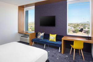 a hotel room with a bed and a desk and a bed and a desk at Aloft Tempe in Tempe