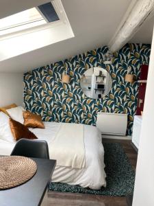 una camera da letto con un letto e carta da parati blu e oro di Studio cocooning et refait à neuf. Lyon 06 a Lione Altre 2 foto