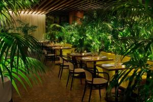 a restaurant with tables and chairs and plants at The West Hollywood EDITION in Los Angeles