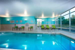 a swimming pool with chairs and tables in a building at Springhill Suites By Marriott Newark Downtown in Newark