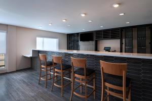 un bar con sgabelli in legno in cucina di TownePlace Suites San Antonio Northwest at The RIM a San Antonio