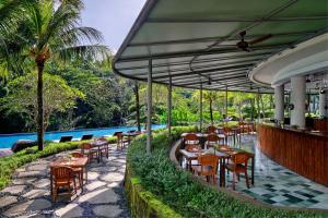 a restaurant with tables and chairs next to a pool at The Westin Resort & Spa Ubud, Bali in Ubud