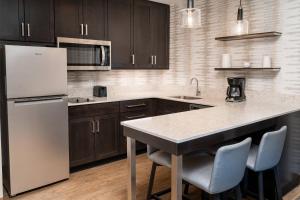 a kitchen with brown cabinets and a white refrigerator at Residence Inn by Marriott Grand Rapids Downtown in Grand Rapids