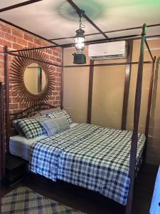 a bedroom with a bed and a mirror and a brick wall at Pondok Tok Wan Homestay in Kampong Kubang Bemban