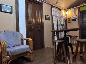 a room with a chair and a table and some stools at Pondok Tok Wan Homestay in Kampong Kubang Bemban