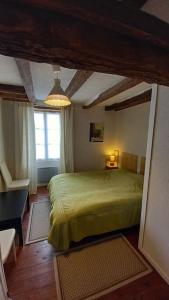 um quarto com uma cama verde e uma janela em Maison Anjou 13 personnes em Montreuil-Bellay
