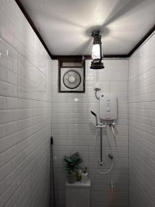 a white tiled bathroom with a shower and a toilet at Pondok Tok Wan Homestay in Kampong Kubang Bemban