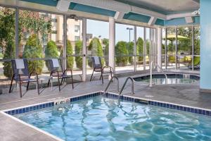 a pool at a hotel with chairs and a table at SpringHill Suites by Marriott Saginaw in Saginaw