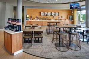 un restaurante con mesas y taburetes y un bar en SpringHill Suites by Marriott Saginaw, en Saginaw