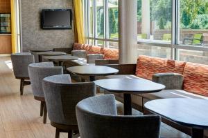 un restaurant avec des tables et des chaises et une télévision dans l'établissement SpringHill Suites by Marriott Saginaw, à Saginaw