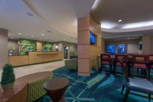a lobby of a hotel with a bar and stools at SpringHill Suites Devens Common Center in Devens