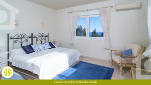 sypialnia z łóżkiem, krzesłem i oknem w obiekcie SolHabitat Villa Cumbre del Sol w mieście Cumbre del Sol +37 zdjęć