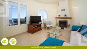 - un salon avec un canapé et une télévision dans l'établissement SolHabitat Villa Cumbre del Sol, à Cumbre del Sol