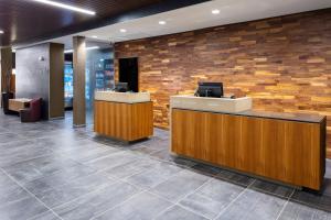 a lobby with a reception desk and a stone wall at Courtyard by Marriott Indianapolis West-Speedway in Indianapolis