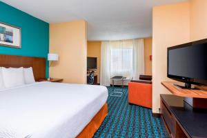 ein Hotelzimmer mit einem Bett und einem Flachbild-TV in der Unterkunft Fairfield Inn & Suites Kansas City Lee's Summit in Lees Summit