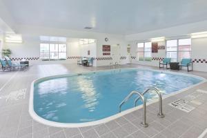 - une piscine dans une salle d'attente avec des chaises et des tables dans l'établissement Residence Inn by Marriott Dallas Lewisville, à Lewisville