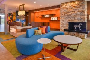 a living room with a blue couch and a fireplace at Fairfield Inn & Suites by Marriott Eugene East/Springfield in Eugene