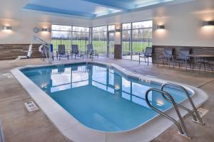 una piscina con sillas y mesas en un edificio en Fairfield Inn & Suites by Marriott Eugene East/Springfield, en Eugene