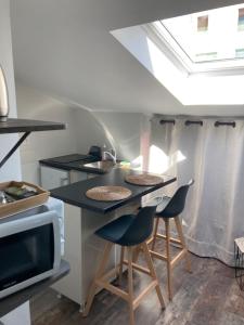 a kitchen with two bar stools and a sink at Studio cocooning et refait à neuf. Lyon 06 in Lyon