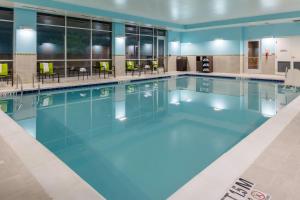 una piscina con acqua blu in una camera d'albergo di SpringHill Suites by Marriott Suwanee Johns Creek a Suwanee