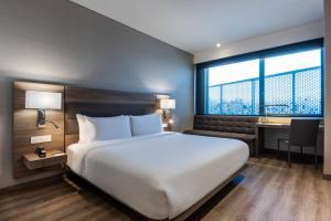 a hotel room with a large bed and a desk at AC Hotel by Marriott Bogota Zona T in Bogotá