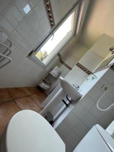 サント・マキシムにあるHotel Princesse D'Azurのバスルーム(トイレ、洗面台付)、窓が備わります。