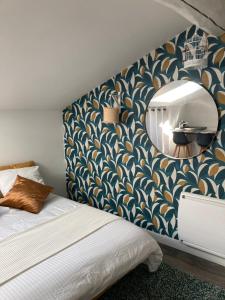 um quarto com uma cama com papel de parede azul e dourado em Studio cocooning et refait à neuf. Lyon 06 em Lyon