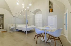 una stanza con un tavolo, sedie e un letto di Palazzo Junno Dimora D'Epoca a Mattinata