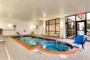 una gran piscina con una silla azul en una casa en SpringHill Suites by Marriott McAllen Convention Center en McAllen