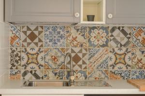 una cucina con lavandino e piastrelle sul muro di Palazzo Junno Dimora D'Epoca a Mattinata Altre 37 foto