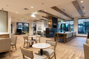 a waiting room with tables and chairs and windows at Residence Inn by Marriott Fort Worth Southwest in Fort Worth
