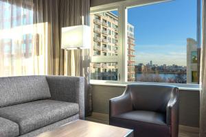 un soggiorno con divano, sedia e finestra di AC Hotel by Marriott Boston North a Medford