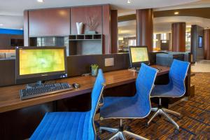 biuro z biurkiem z komputerem i niebieskimi krzesłami w obiekcie Courtyard Boston-South Boston w mieście Boston