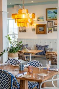 a dining room with a table and chairs and a chandelier at The Godolphin Hotel in Marazion